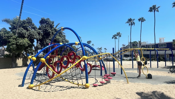 A playground with climbing structures and a sand area.