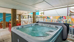 Un bain à remous installé dans un espace extérieur doté d’une terrasse en bois et d’une clôture.