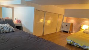 A bedroom with a bed, bedside table, wardrobe, and a nightstand. - Seoul Apartment. Great location, close to tourist attractions, Wi-Fi. (Seoul)