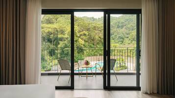 Ein Zimmer mit einer großen Schiebeglasdoor, die auf einen Balkon mit Pool und Sitzgelegenheiten führt.