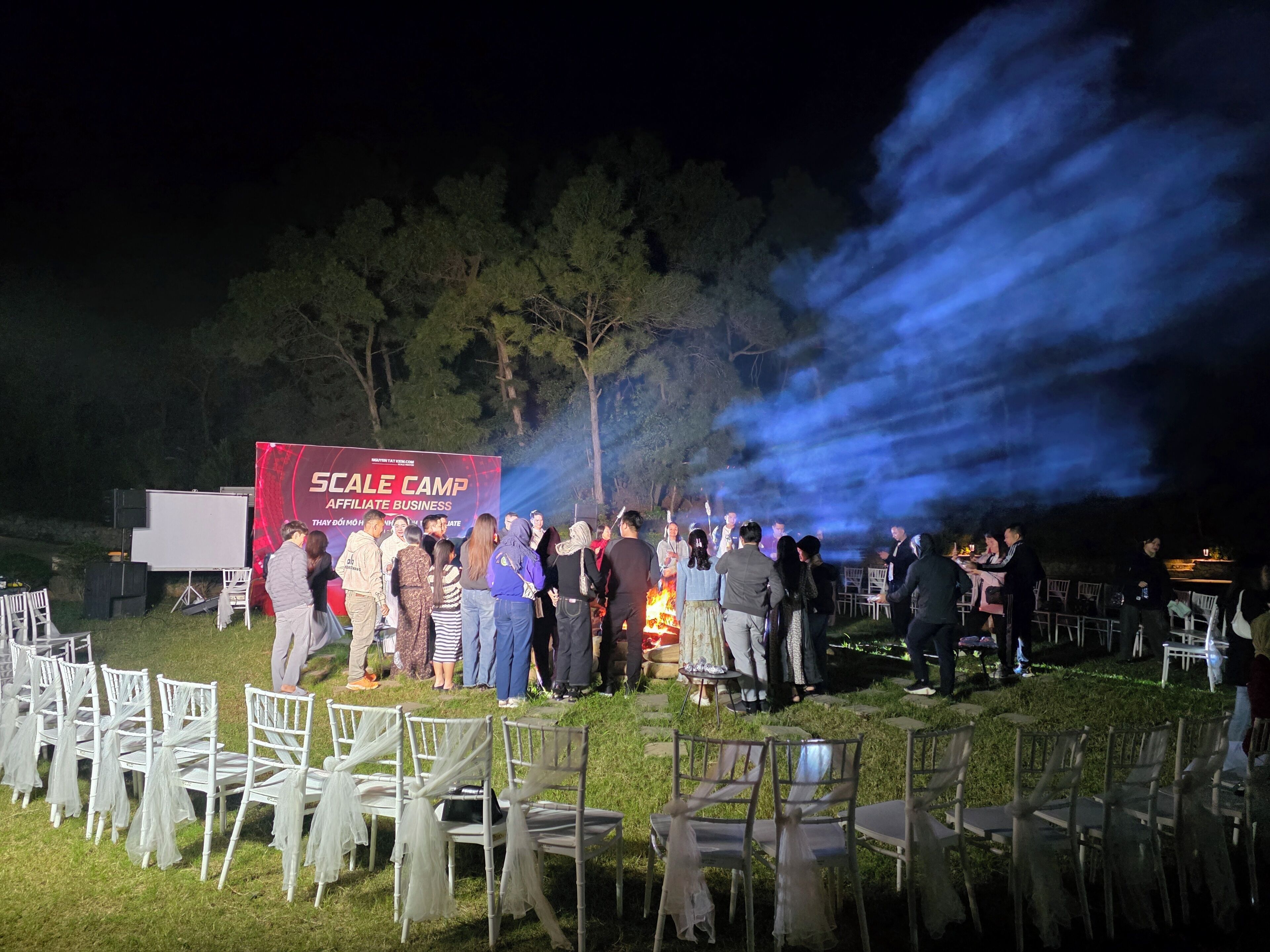 An outdoor event with a stage and chairs arranged for guests.