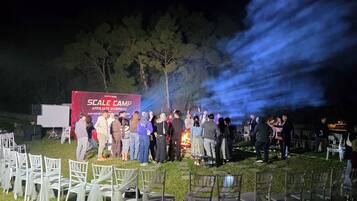 An outdoor event with a stage and chairs arranged for guests.