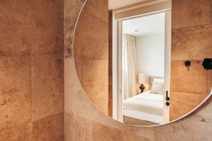 A bathroom with a large mirror reflecting a bedroom. - ONE Mambo 20 – 2BR Oceanview LUX Condo by Bocobay (Willemstad)