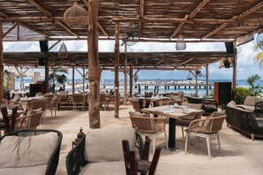 An outdoor seating area with wicker furniture and a view of the beach and ocean.