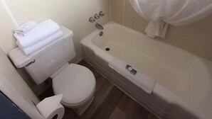 Un bany amb vàter, banyera i cortina de dutxa.