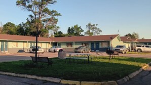 Motel amb diverses habitacions, un pàrquing i una zona de taules de pícnic.