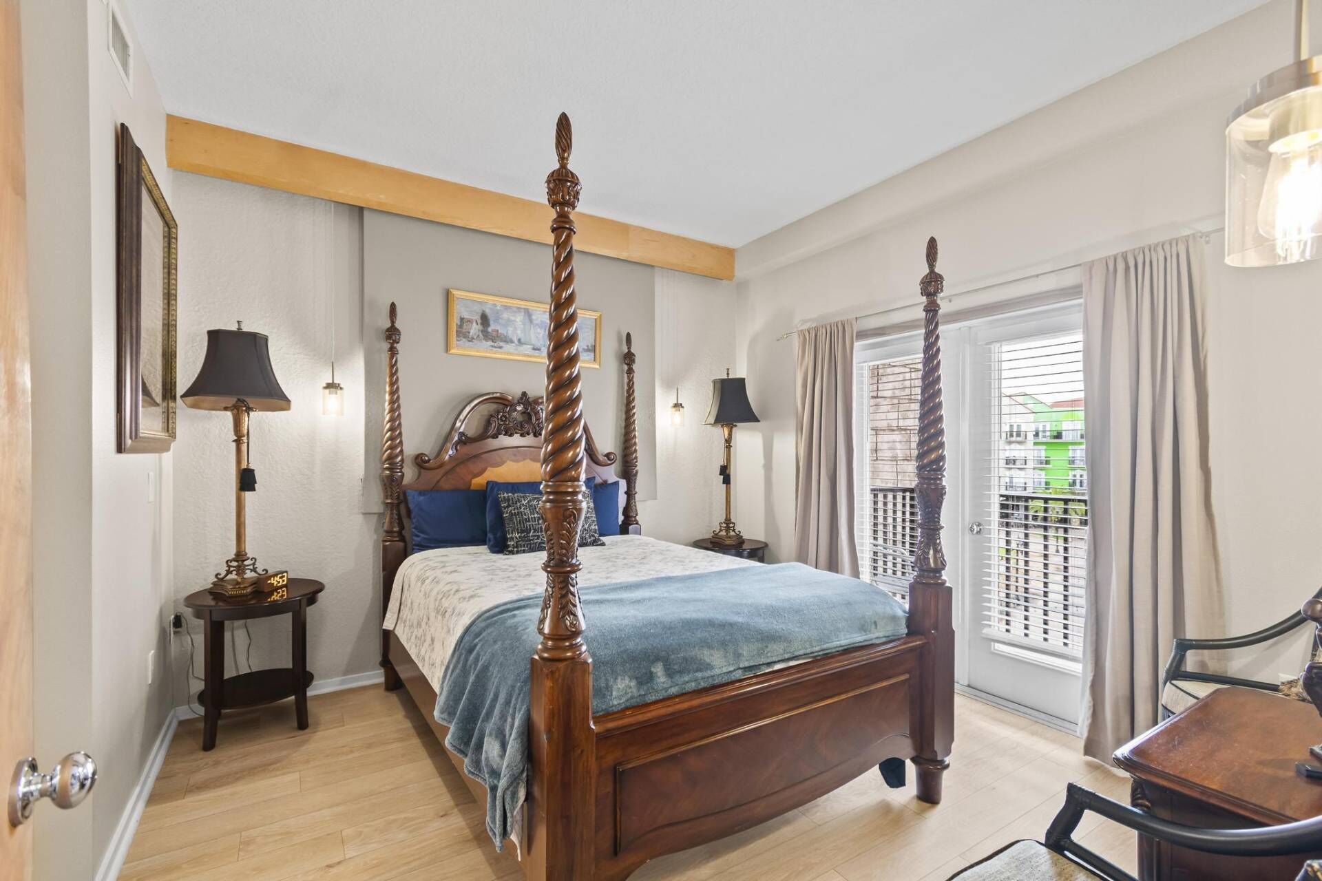 A four-poster bed with a wooden headboard, two bedside tables, and a nightstand.