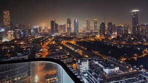 A nighttime cityscape with high-rise buildings and illuminated streets. - 16th floor wonderland- 2 Bedroom (Dubai)