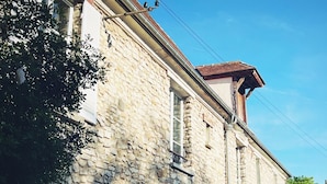 A stone building with a traditional architectural style, featuring a pitched roof and multiple windows.