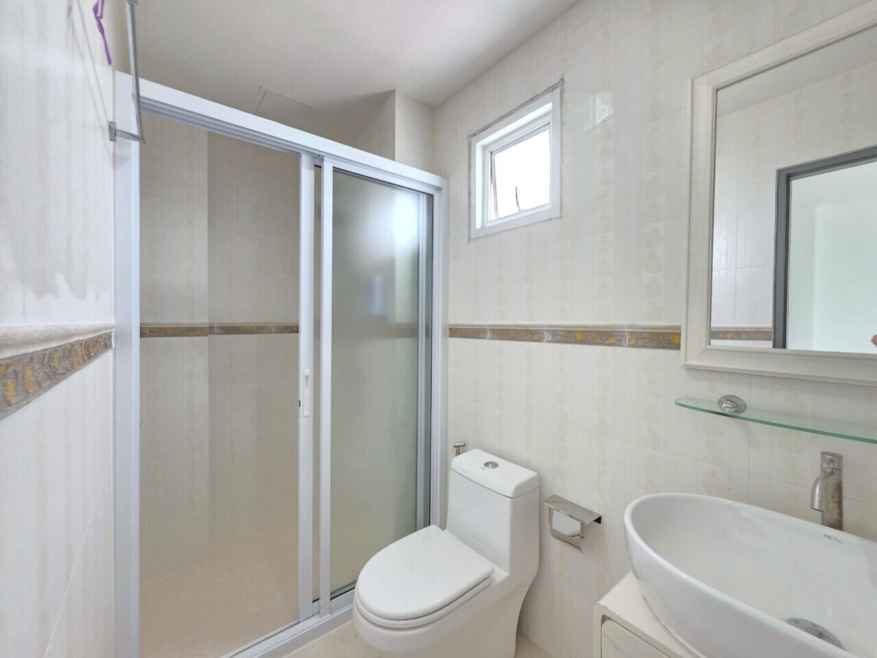 Un baño con cabina de ducha de vidrio, inodoro, lavabo y espejo.