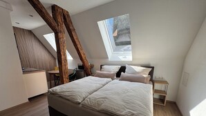 A modern bedroom with a large bed, a desk, and a skylight. - Vacation apartment Cochem Mosel Pinnerbergstube (Cochem)