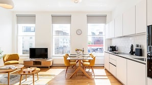 Een modern appartement met een eetgedeelte, keuken en woonkamer.