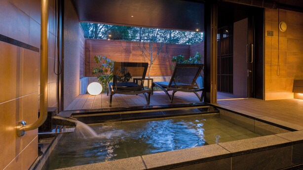 A modern spa area with a hot tub, wooden flooring, and a seating area with chairs and a table. - Rakuten STAY VILLA Hakone Togendai (Hakone)