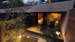 A modern house with a glass door leading to a patio area with a bench and a small table. - Rakuten STAY VILLA Hakone Togendai (Hakone)
