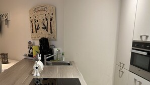 Eine moderne Küche mit Kochinsel, Edelstahlgeräten und minimalistischem Design.