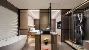 A modern bathroom with a large bathtub, a vanity with a mirror, and a shower area.