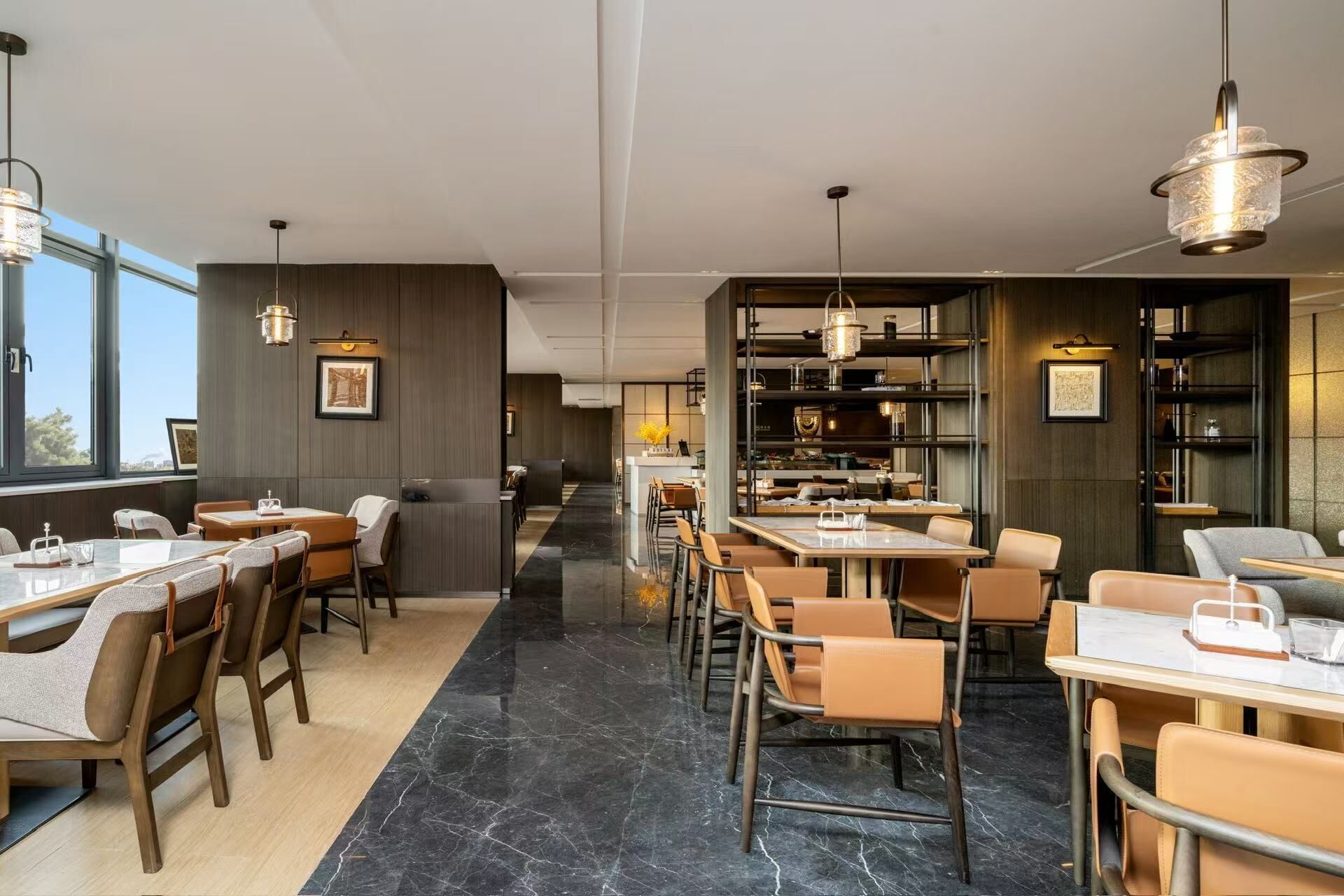 Ein modernes Restaurant mit hohen Decken, Marmorböden und einer Mischung aus Holz- und Ledermöbeln.