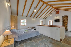 Ein Schlafzimmer mit Bett, Nachttischlampe und einem kleinen Schreibtisch mit Lampe.