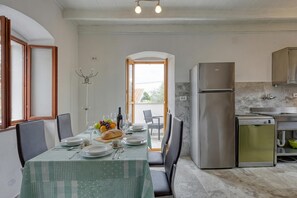 Ein Essbereich mit einem Tisch für vier Personen, einem Edelstahl-Kühlschrank und einem integrierten Geschirrspüler.