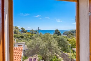 A view from a window overlooking a coastal area with trees and a clear sky. - Casa Lussingrande Island Retreat With Terrace (Mali Losinj)