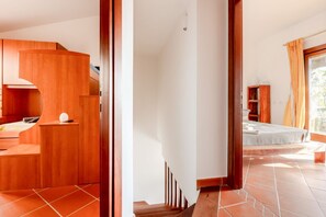 Un intérieur moderne avec un escalier en bois, un lit et un petit coin salon.