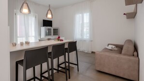 Eine moderne Küche mit Essbereich, einer Sitzecke und einem Fernseher.