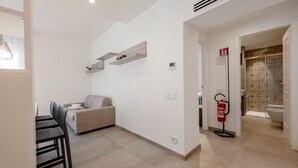 Ein modernes Interieur mit Essbereich, Sofa und Feuerlöscher.