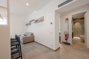 A modern interior with a dining area, sofa, and a fire extinguisher.