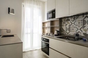 A modern kitchen with a built-in oven, a microwave, and a coffee maker on the counter.