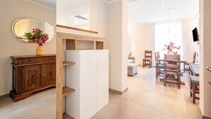 Een modern interieur met een houten kast, een witte plankenwand en een eethoek met houten stoelen en een tafel.