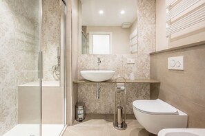 Een douche, een haardroger, een bidet, handdoeken