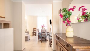 Une cuisine moderne avec des meubles en bois, un vase rempli de fleurs et un coin repas comprenant des chaises et une table.