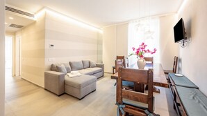 Un salon moderne avec un canapé, une table à manger et des chaises.