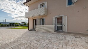 Un edificio a due piani con un balcone, una porta e una finestra.
