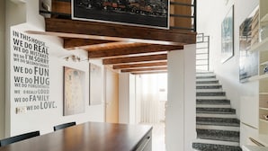 Un intérieur moderne comprenant une cuisine, un coin repas et un escalier.