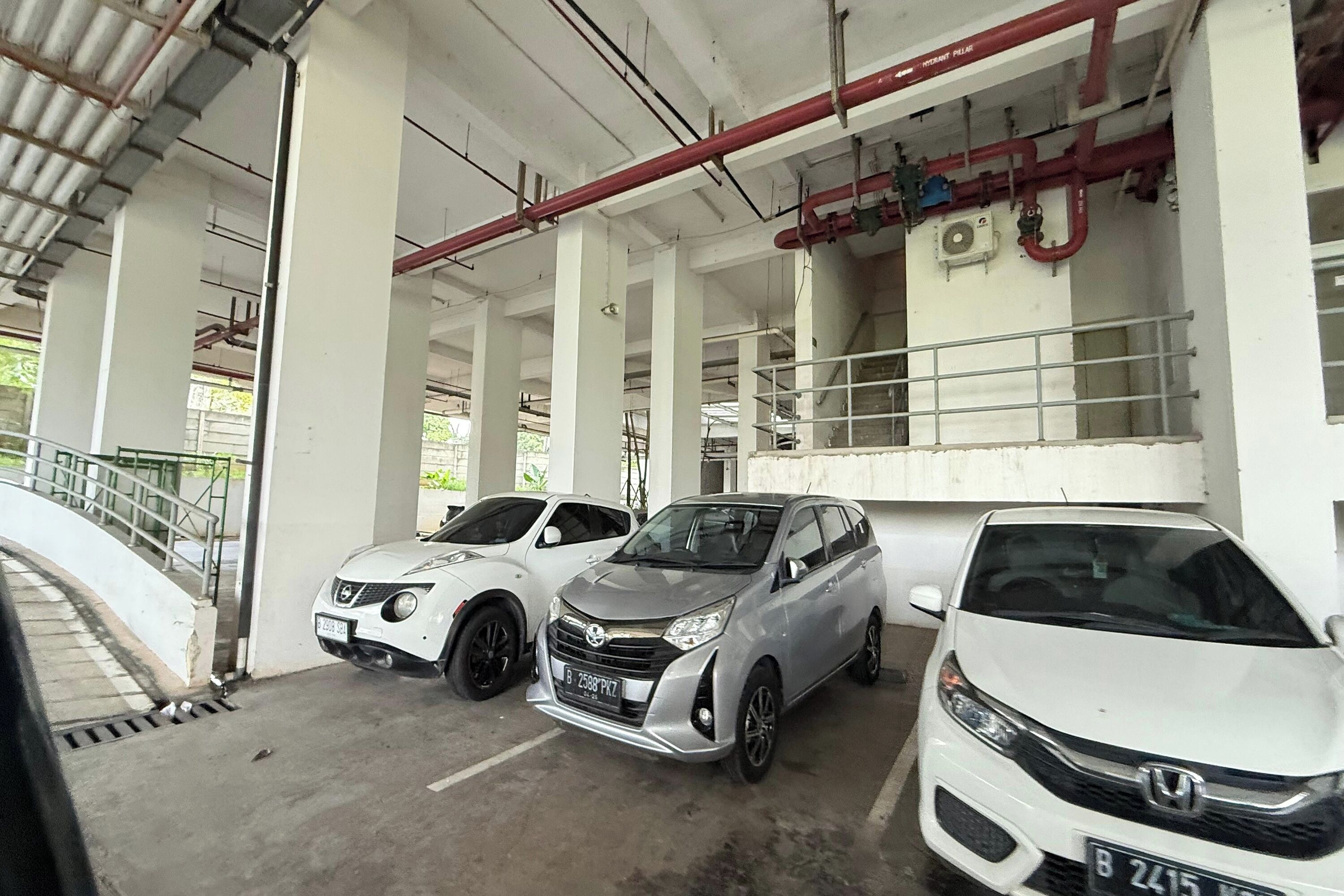 Eine Parkgarage mit drei in einer Reihe geparkten Autos.