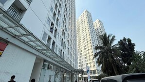 A modern high-rise building with a glass facade and multiple balconies. - Serpong Garden NATURE INN (Cisauk)
