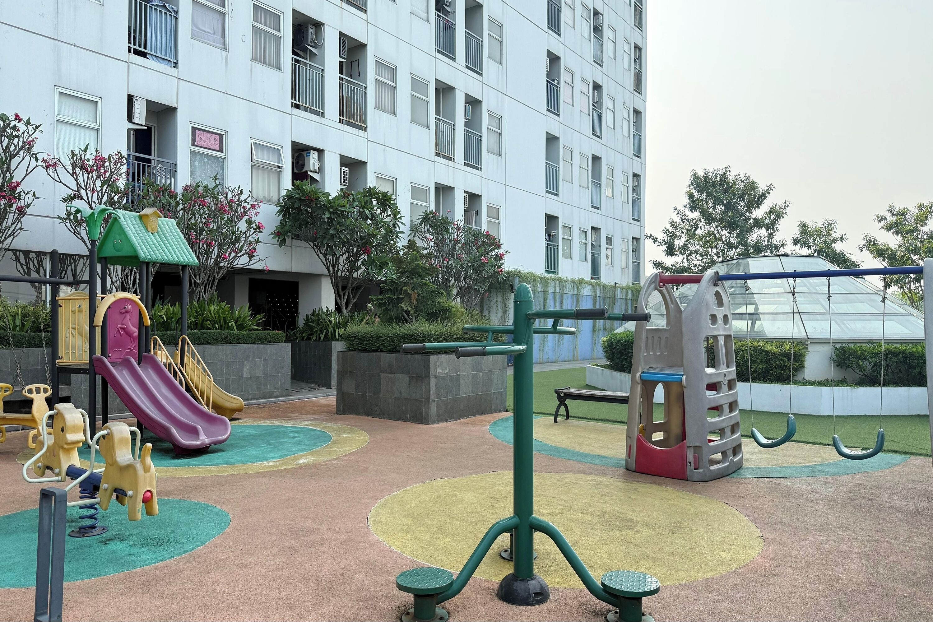 A playground with swings, a slide, and exercise equipment.