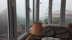 A room with a large window, a lamp, and a chair.