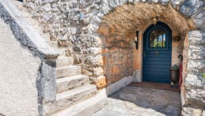 A stone staircase leading to a dark blue door with a decorative archway.