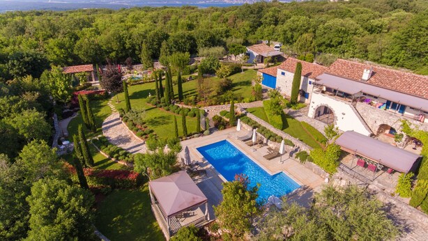 A large property with a swimming pool, multiple buildings, and extensive landscaping.