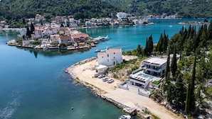 A coastal town with a marina, modern buildings, and a large body of water. - Villa Juma by Villas Guide (Blace)