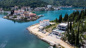 Un pueblo costero con un puerto deportivo, edificios modernos y una extensa masa de agua.