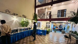 A multi-level indoor space with a patterned floor, a buffet setup, and a staircase connecting the levels. - Krishna Villa  (Varanasi)