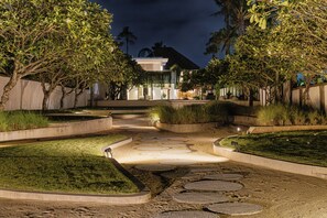 Un área exterior con jardines, senderos y un edificio al fondo.