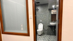 Une salle de bain avec des toilettes, un lavabo et une douche.