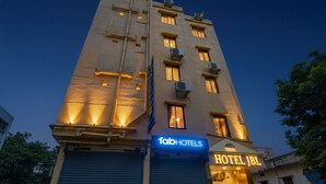 Ein mehrgeschossiges Gebäude mit den Schildern "fabHOTELS" und "HOTEL JBL", das mehrere Hotels beherbergt.