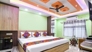 Ein modernes Hotelzimmer mit Bett, Schreibtisch, Stuhl und Deckenventilator.