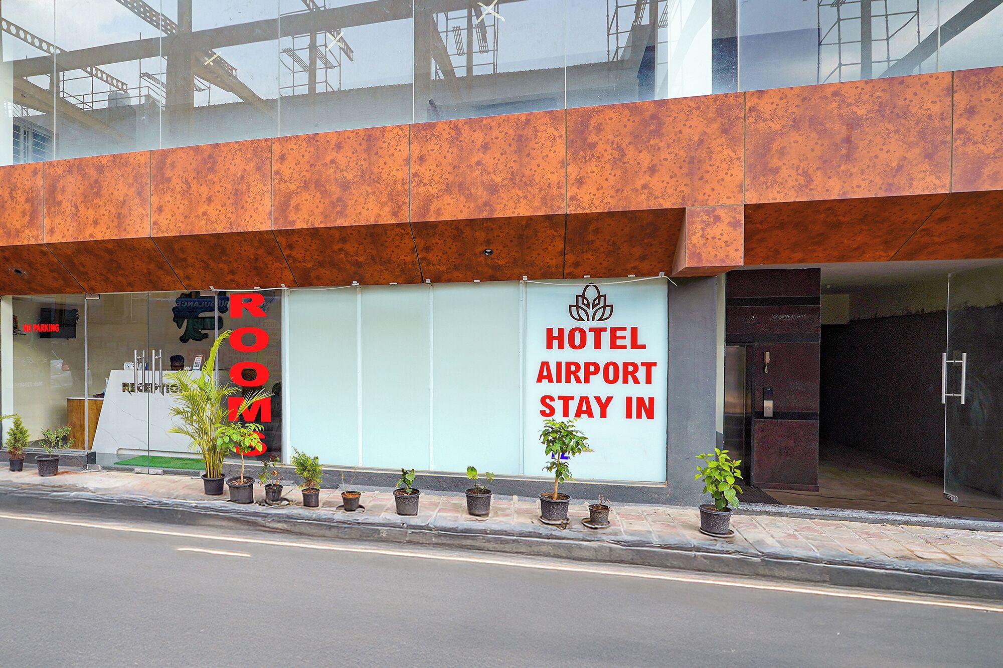 A hotel with a sign reading "HOTEL AIRPORT STAY IN" and a "ROOM" sign above the entrance.