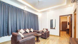 A modern living room with a sofa set, a coffee table, and a mirror on the wall. - FabHotel Airport Stay Inn - Near Kempegowda Airport (Bangalore)